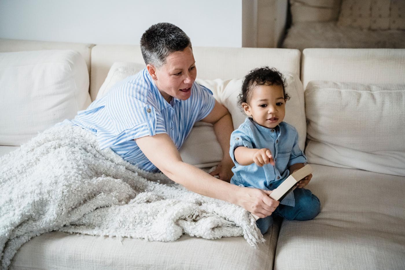 A tender moment of a mother and toddler bonding on a cozy sofa at home