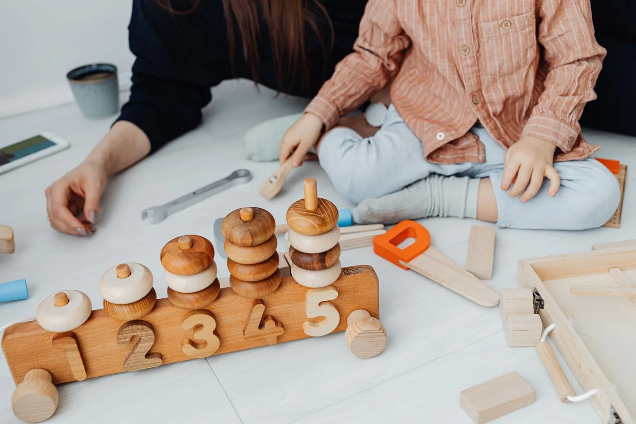 A young child playing with wooden learning toys